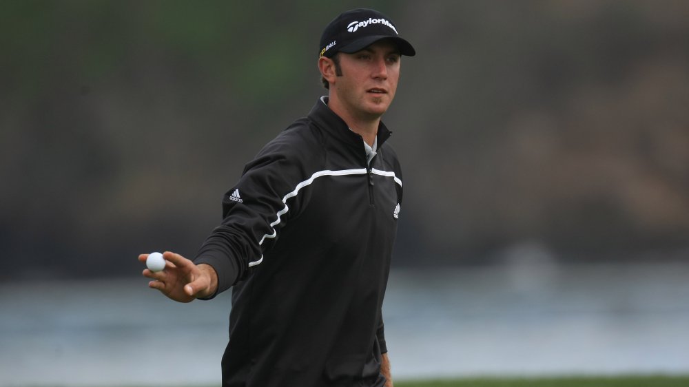 Dustin Johnson wearing all black, walking during a golf match