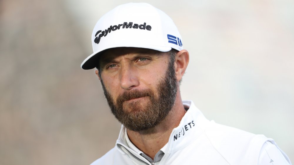 Dustin Johnson in white, looking focused during a 2020 match