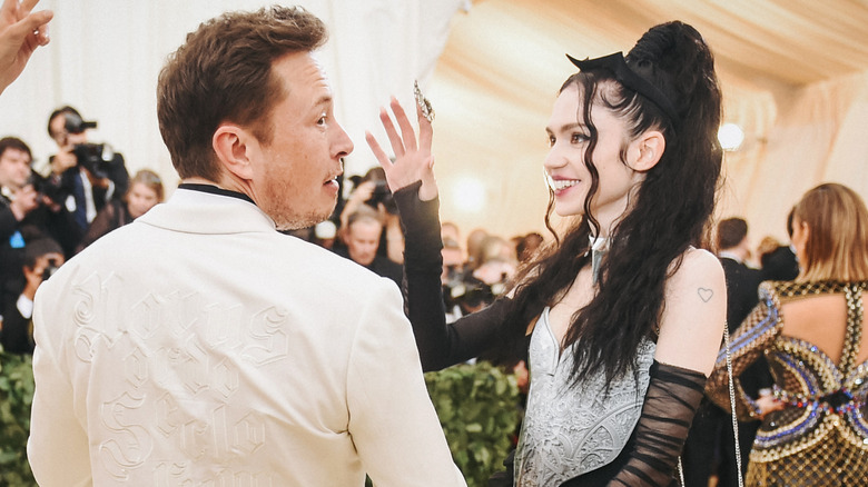 Grimes and Elon Musk posing 