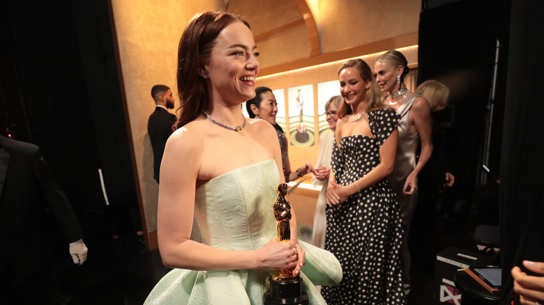 Emma Stone smiling backstage at the 2024 Oscars