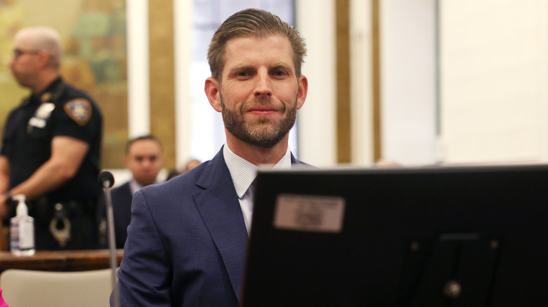 Eric Trump smiling behind computer