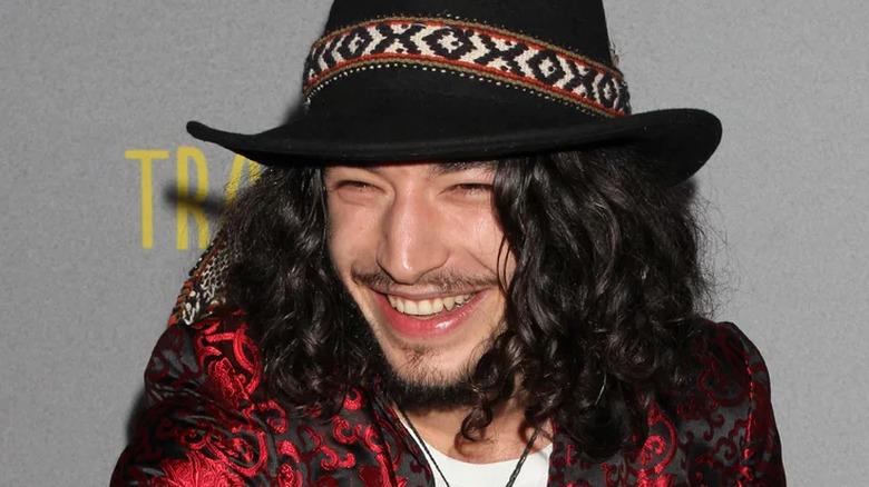 Ezra Miller wearing a red jacket and hat