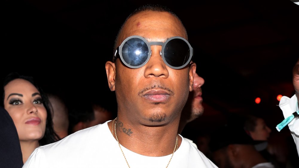 Ja Rule in a white t-shirt and black sunglasses, posing with a serious expression