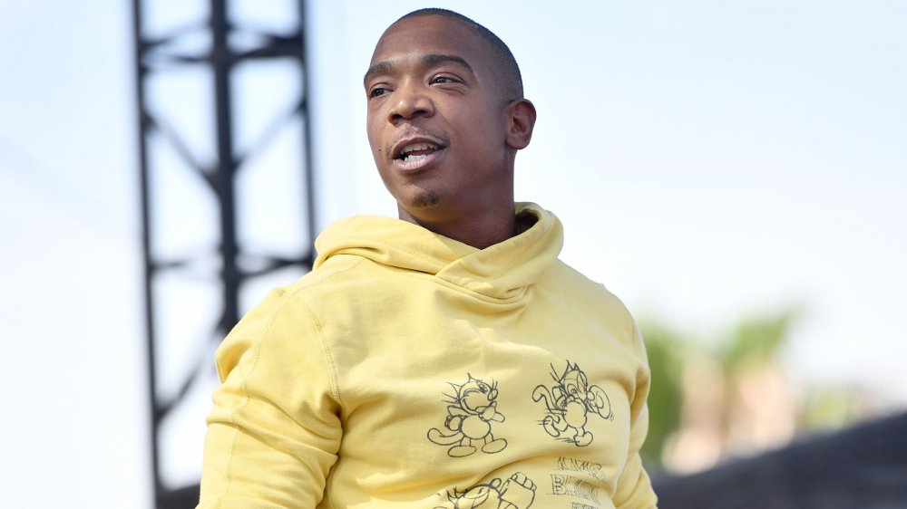 Ja Rule in a yellow hoodie, smiling during an outdoor performance