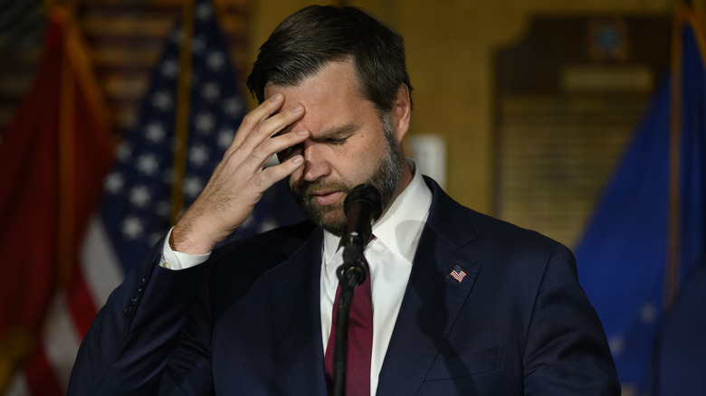 JD Vance holding his head in his hand