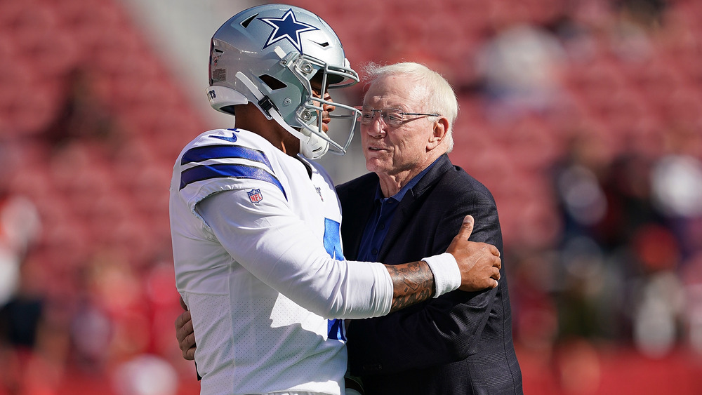 Dak Prescott and Jerry Jones embracing on the field 