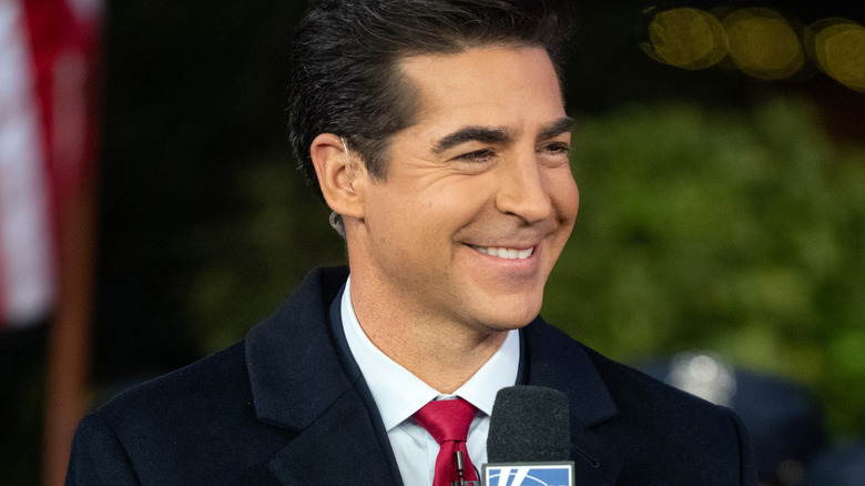 Jesse Watters holding a microphone