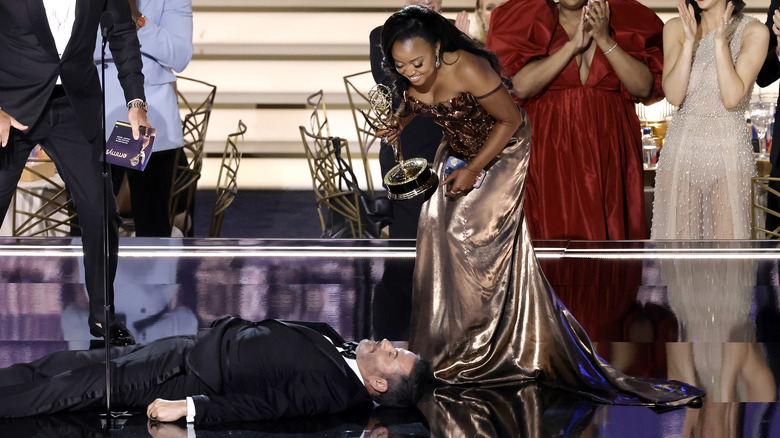 Jimmy Kimmel laying down on stage with Quinta Brunson looking at him