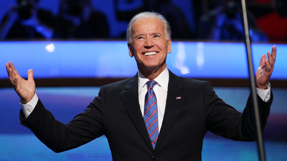 Joe Biden smiling with his arms raised