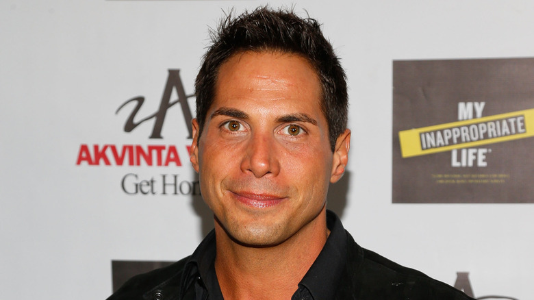 Joe Francis standing in front of a step-and-repeat