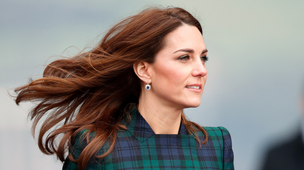 Kate Middleton smiling with her hair blowing in the wind