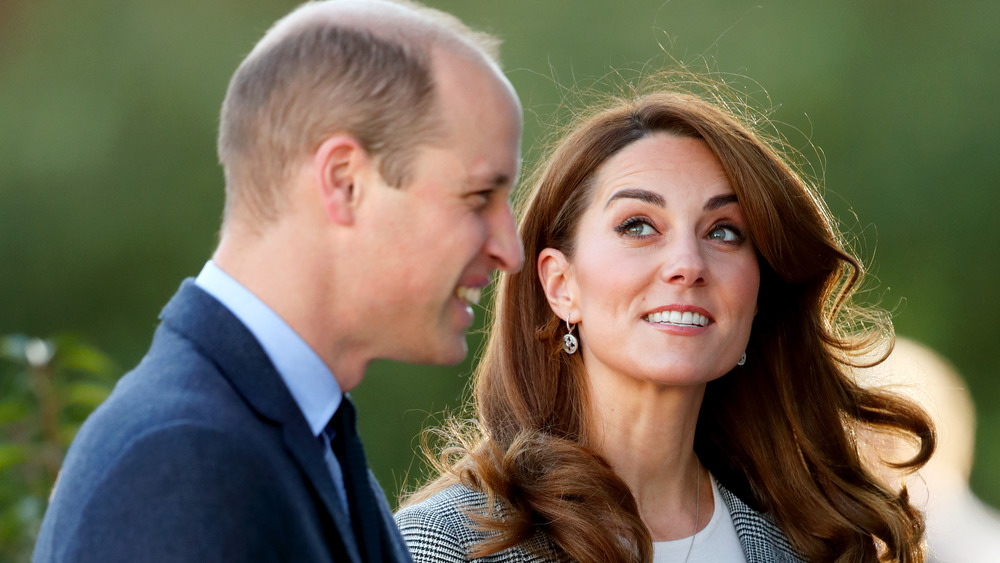 Prince William and Kate Middleton smiling outside 