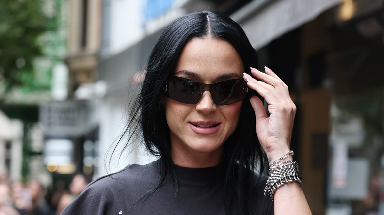 Katy Perry wearing a black t-shirt and black sunglasses on the street