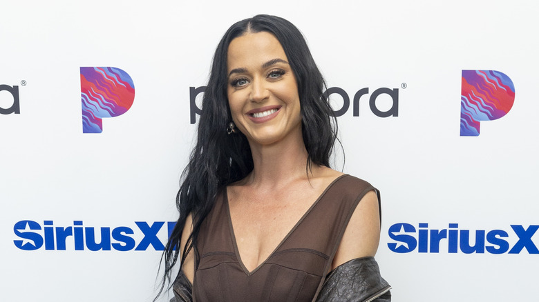 Katy Perry wearing a brown sheer tank top blouse and a black leather jacket