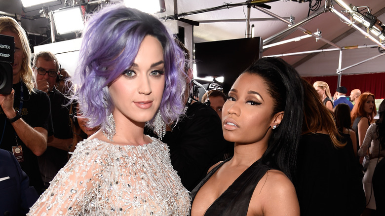 Katy Perry wearing a silver sparkling gown and Nicki Minaj wearing a black halter gown