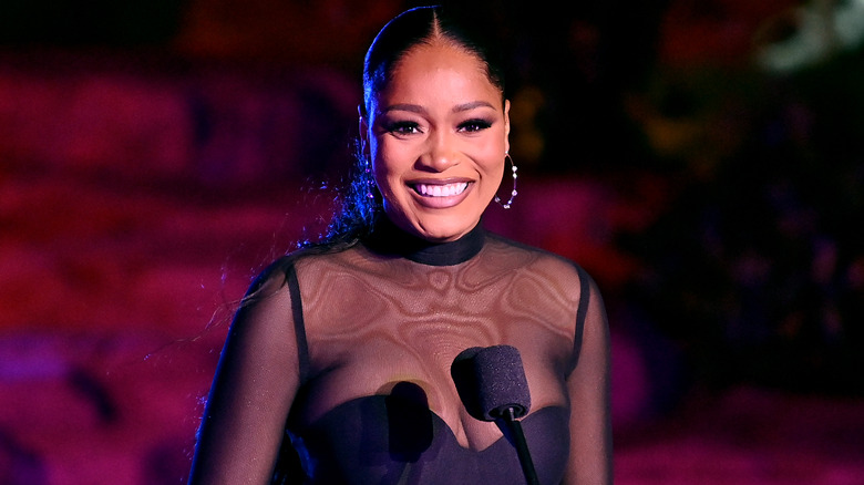 Keke Palmer, smiling in front of microphone