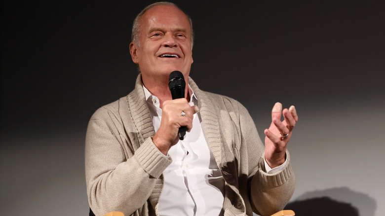 Kelsey Grammer sitting in chair and speaking on stage