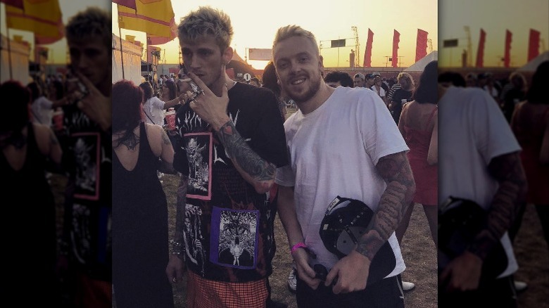 Machine Gun Kelly stands next to a fan