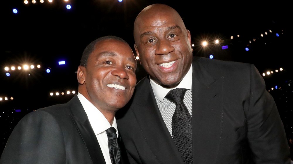 Isiah Thomas and Magic Johnson in suits, smiling