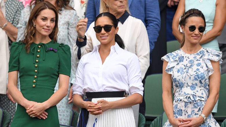 Kate Middleton, Meghan Markle, and Pippa Middleton standing