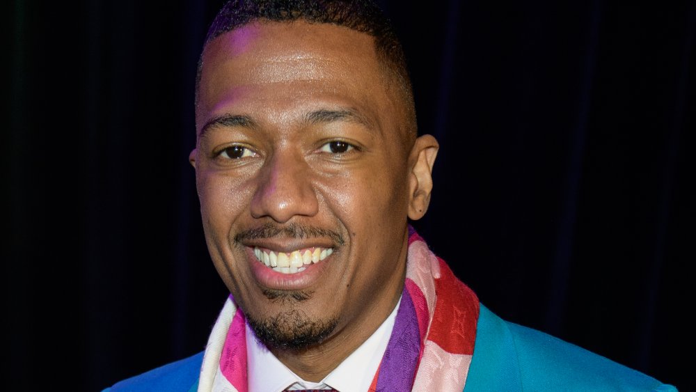 Nick Cannon wearing a blue suit and scarf 