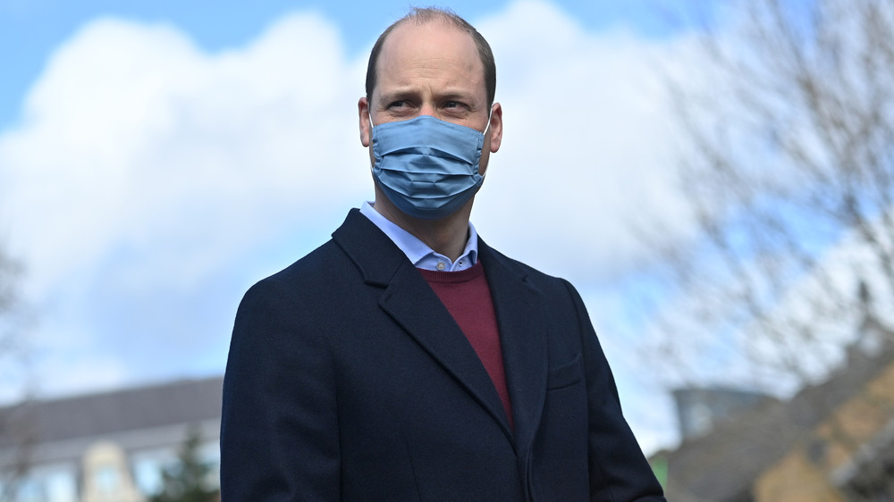 Prince William wearing a mask and walking