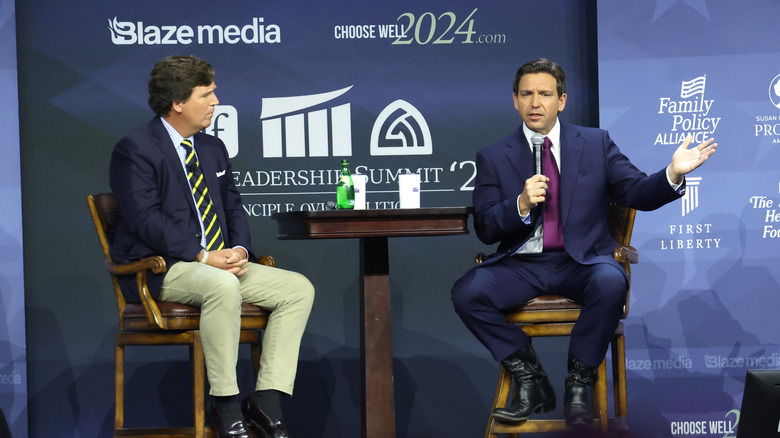 Tucker Carlson and Ron DeSantis sitting