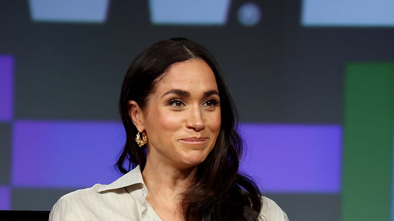 Meghan Markle long wavy hair gold hoop earrings