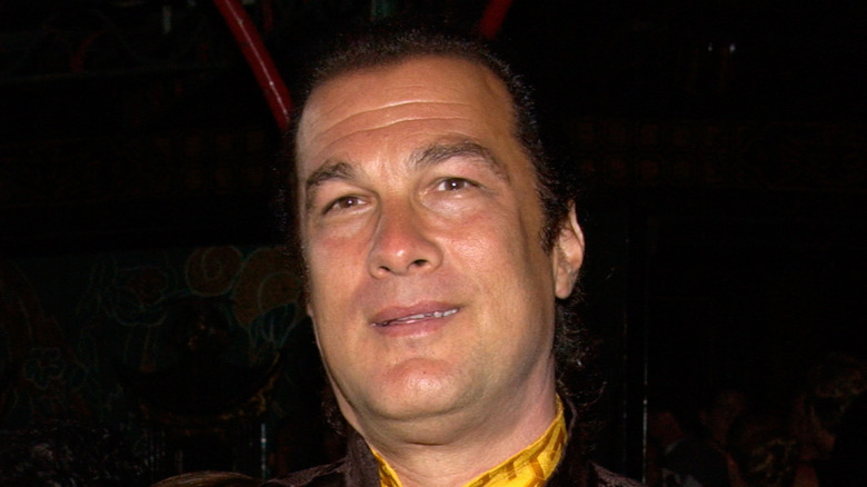 Steven Seagal in smiling in yellow shirt