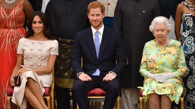 Meghan Markle, Prince Harry, and Queen Elizabeth seated together 