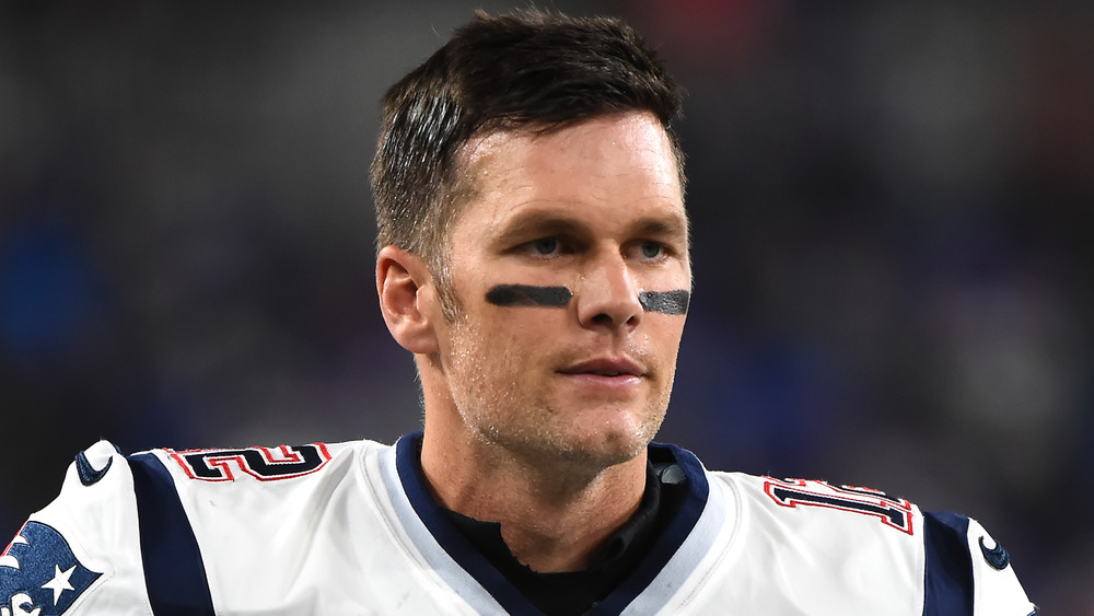 Tom Brady suited up and looking serious on the field 