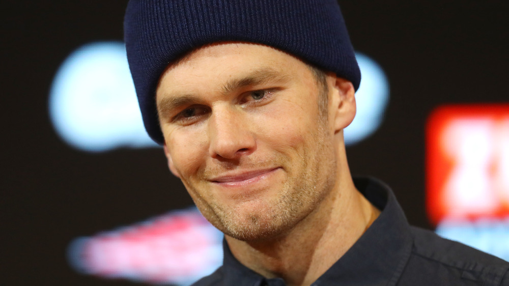 Tom Brady wearing a beanie and smirking 