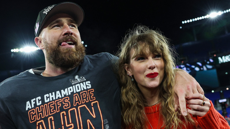 Travis Kelce and Taylor Swift stand together on football field