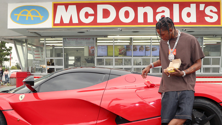 Travis Scott standing in front of a McDonald's