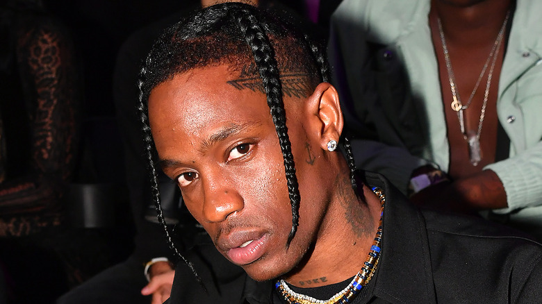 Travis Scott wearing a necklace and beads