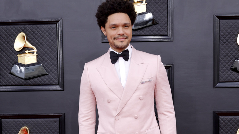 Trevor Noah, smirking at Grammys red carpet