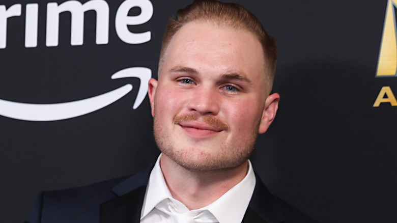 Zach Bryan smirking on red carpet