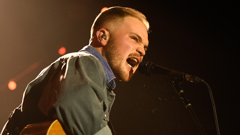 Zach Bryan singing on stage