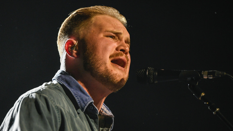 Zach Bryan vocalizing on stage