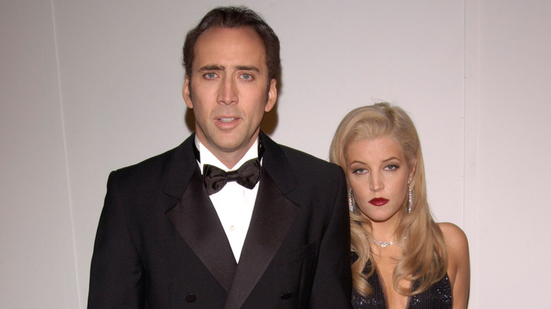 Nicolas Cage in tuxedo and Lisa Marie Presley with blonde hair