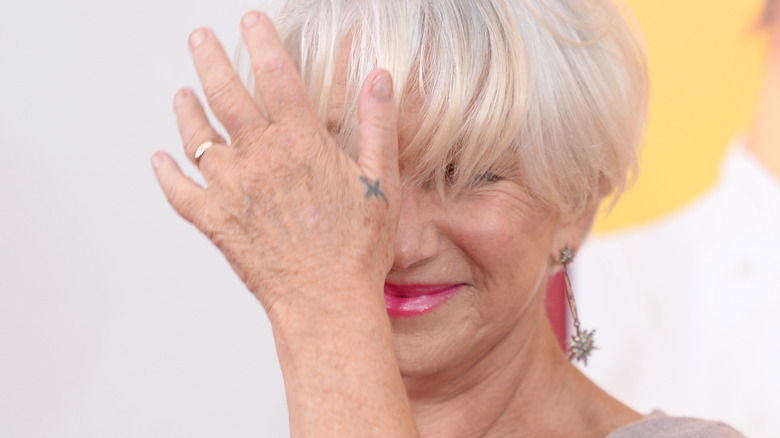 Helen Mirren holding hand over face