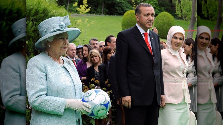 The queen holding a football with the Turkish Prime Minister