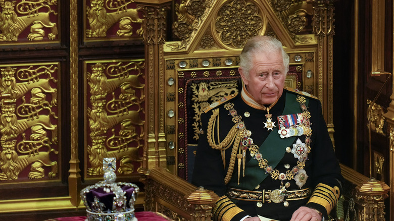 King Charles sits next to a crown