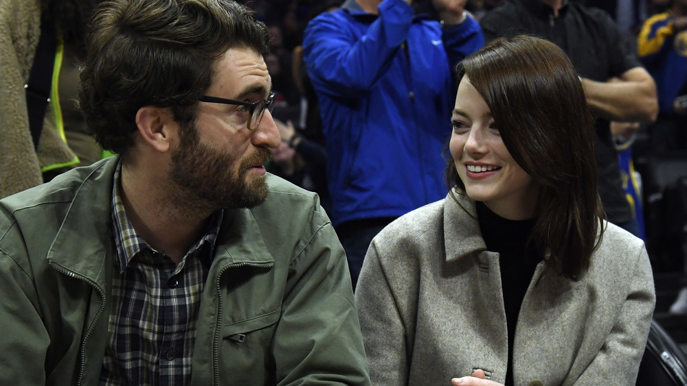 Dave McCary and Emma Stone sit courtside