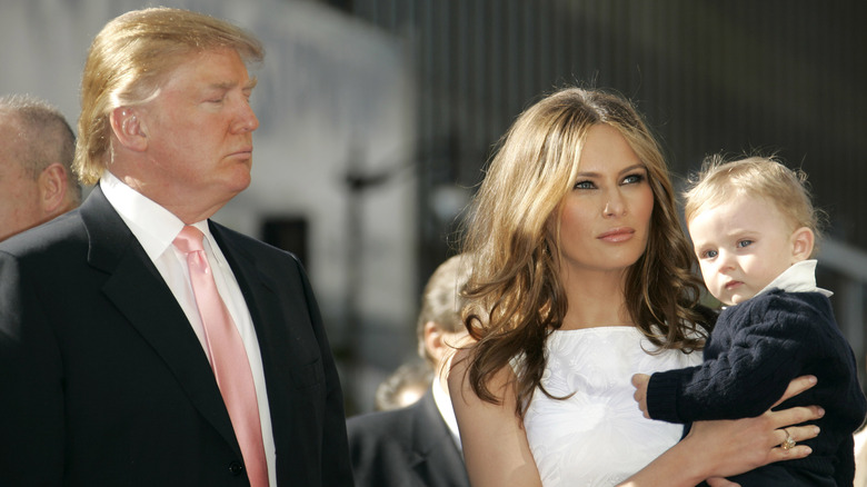 Melania Trump holding Barron Trump beside Donald Trump