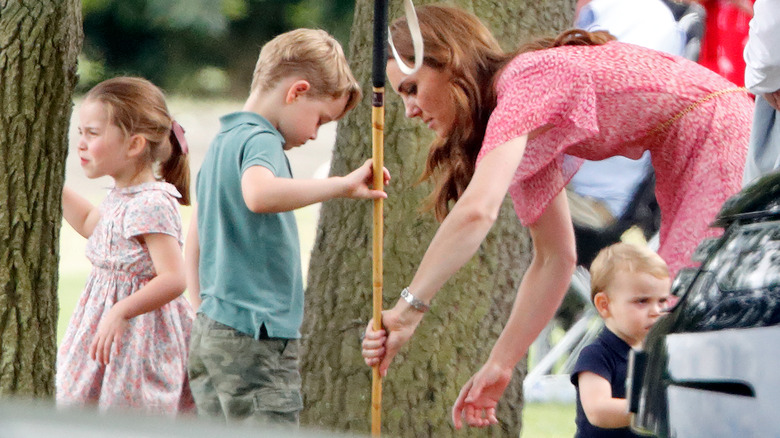 Princess Charlotte, Prince George, Kate Middleton, and Prince Louis playing outdoors