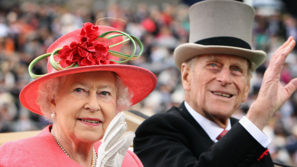 Prince Philip and Queen Elizabeth waving to a crowd