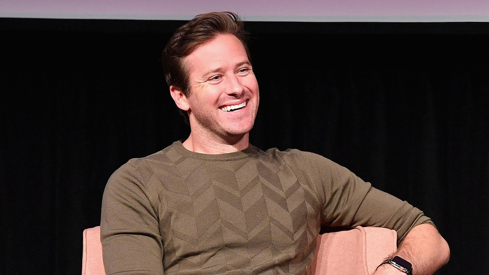 Armie Hammer laughing and sitting