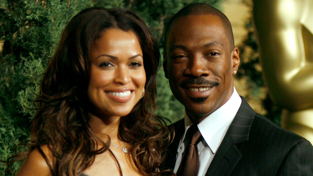 Tracey Edmonds and Eddie Murphy smiling on a red carpet