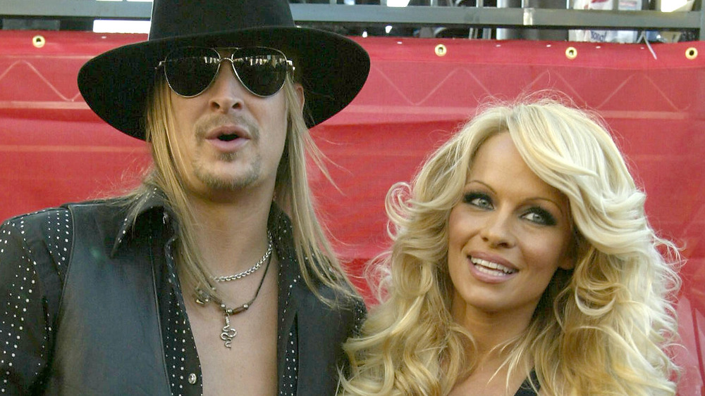 Kid Rock and Pamela Anderson embracing on a red carpet 